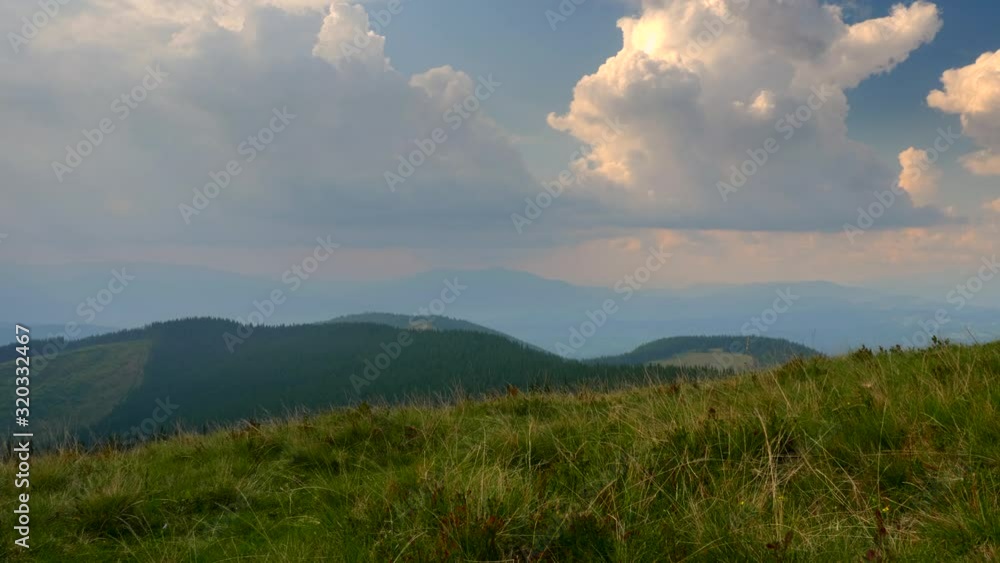 Scenic Panorama View On Top of the Mountain. Carpathian Mountains Peaks. Clouds Woods Meadows Grass Scenic Panorama View On Top of the Mountain. Carpathian Mountains Peaks. Clouds Woods Meadows Grass