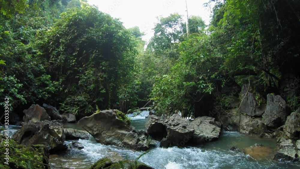 A beautiful, small rocky waterfall in the forest of Khao Sok National Park in Thailand - wide tilt up A beautiful, small rocky waterfall in the forest of Khao Sok National Park in Thailand - wide tilt up