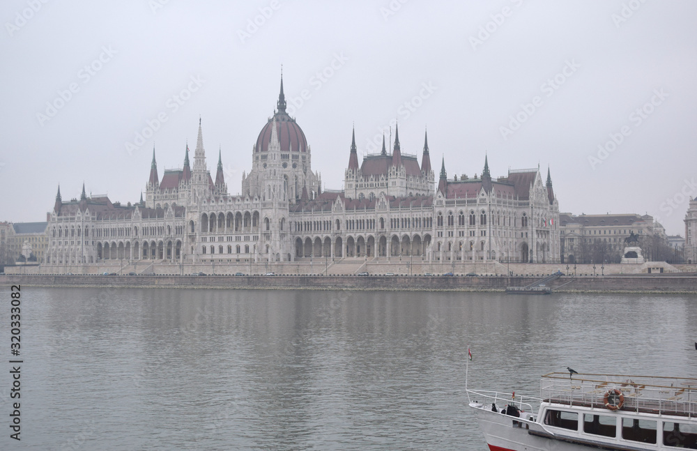 Fototapeta premium Ship on Danube river, Parliament in the fog background