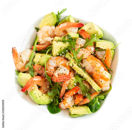 Salad with avocado, shrimp and arugula in white bowl
