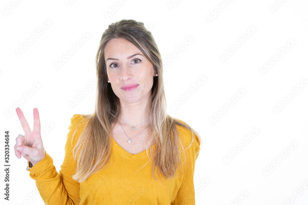 Victory gesture concept happy beautiful woman making peace sign with two fingers aside blank copy space isolated over white background Victory gesture concept happy beautiful woman making peace sign with two fingers aside blank copy space isolated over white background