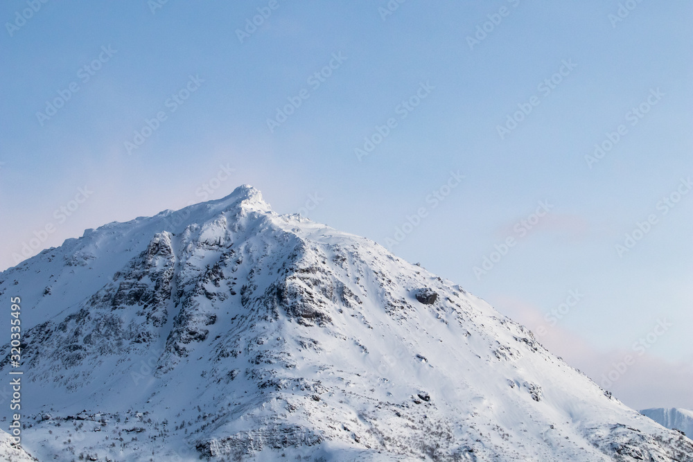 Mountain silhouette profile in arctic landscape with snow and ice. Snowy mountain on a blue sky and clouds, profile of a mountain with snow and ice. Winter landscape