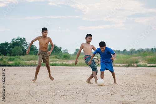 Action sport outdoors of kids having fun playing soccer football for exercise in community rural area