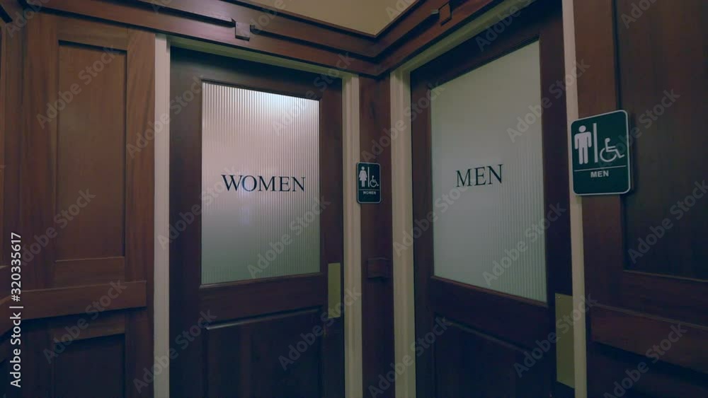 Panning shot of two indoors restroom entrances. Panning shot of two indoors restroom entrances.