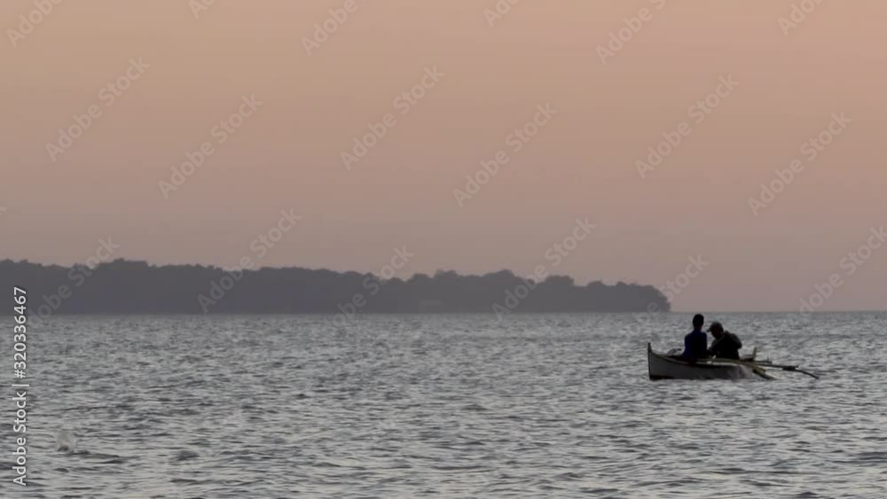 Two fisherman in a small boat catching fish, SBMA, Philippines Two fisherman in a small boat catching fish, SBMA, Philippines