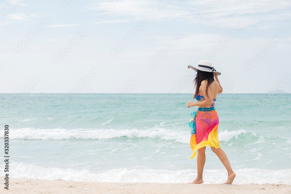 Happy traveler asian woman standing on beach enjoys her tropical vacation Happy traveler asian woman standing on beach enjoys her tropical vacation