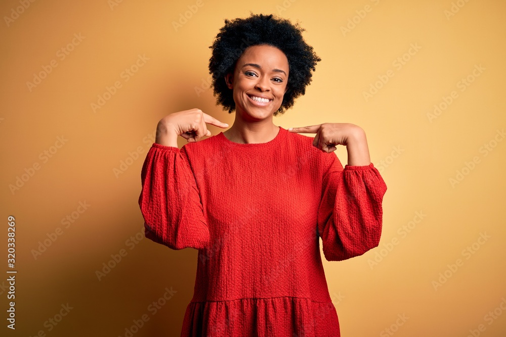 Young beautiful African American afro woman with curly hair wearing casual sweater looking confident with smile on face, pointing oneself with fingers proud and happy. Young beautiful African American afro woman with curly hair wearing casual sweater looking confident with smile on face, pointing oneself with fingers proud and happy.
