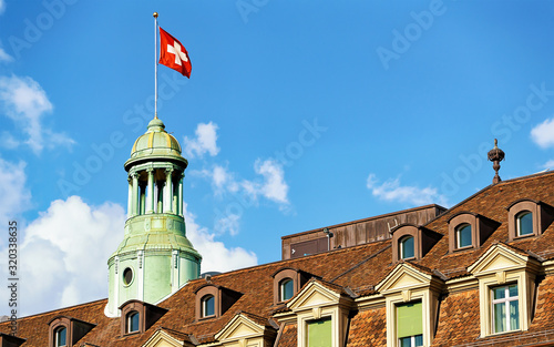 Tower with Swiss flag and roof covered with tiles in Bern, Switzerland. Mixed media. photo