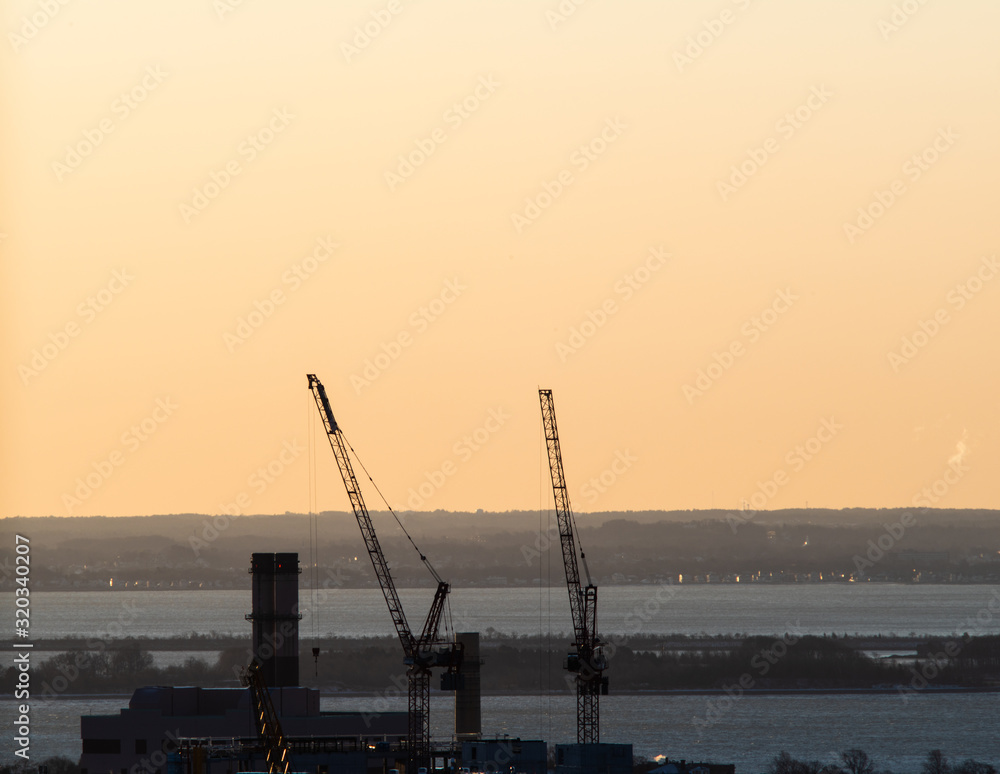 Fototapeta premium Two Cranes Silhouetted at Dawn In Boston Massachusetts