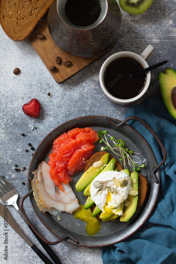 Valentine's day breakfast. Boiled egg sandwich with avocado, coffee, salmon and smoked salmon on a stone concrete tabletop. Top view flat lay background. Valentine's day breakfast. Boiled egg sandwich with avocado, coffee, salmon and smoked salmon on a stone concrete tabletop. Top view flat lay background.