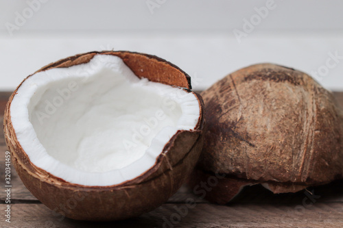 two halves of a coconut on a wooden table