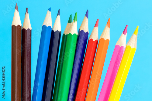 Multi color pencils on a blue background. School concept