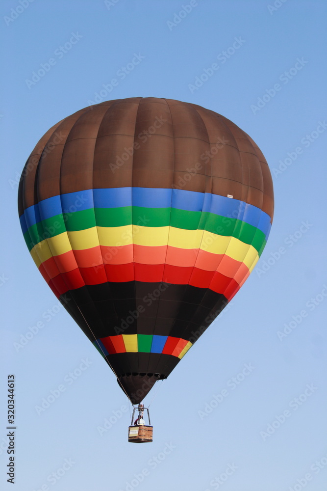 Obraz premium Rainbow colors Hot Air Balloon over a blue Miami sky