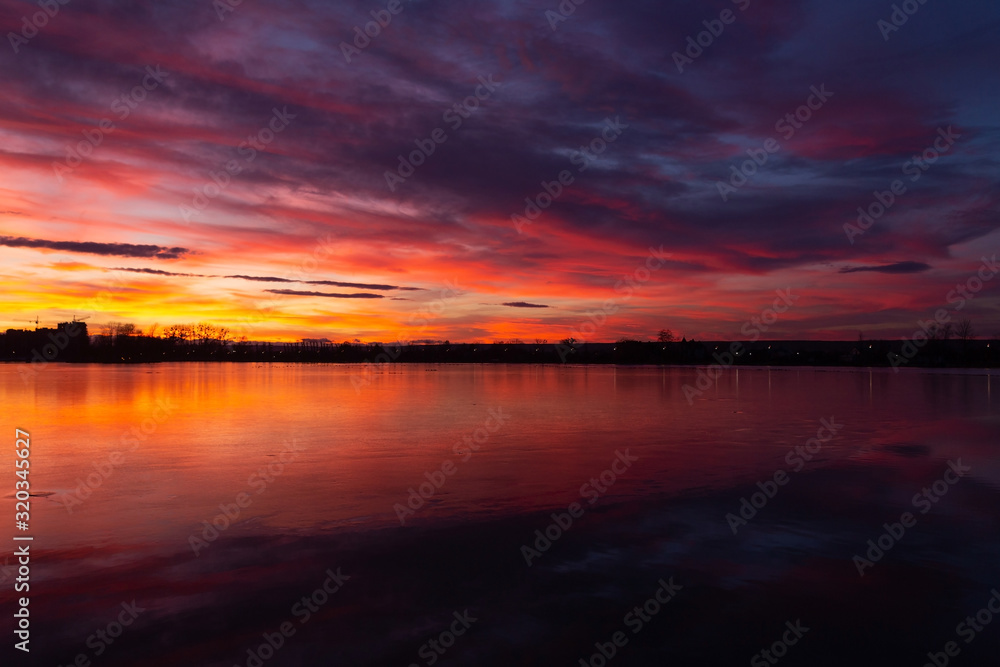 the majestic sunset over the lake. colorful saturated clouds reflected in water. dramatic scene. beautiful landscape. color in nature. beauty in the world