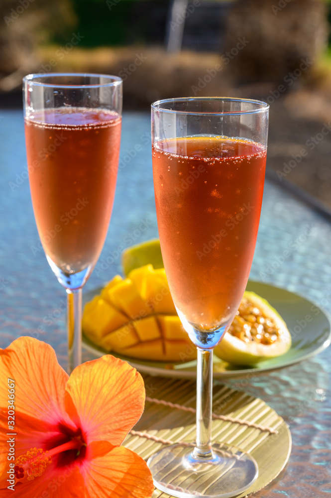 Two glasses of rose bubbles champagne or cava wine served outside on paradise island with palms and green grass Two glasses of rose bubbles champagne or cava wine served outside on paradise island with palms and green grass