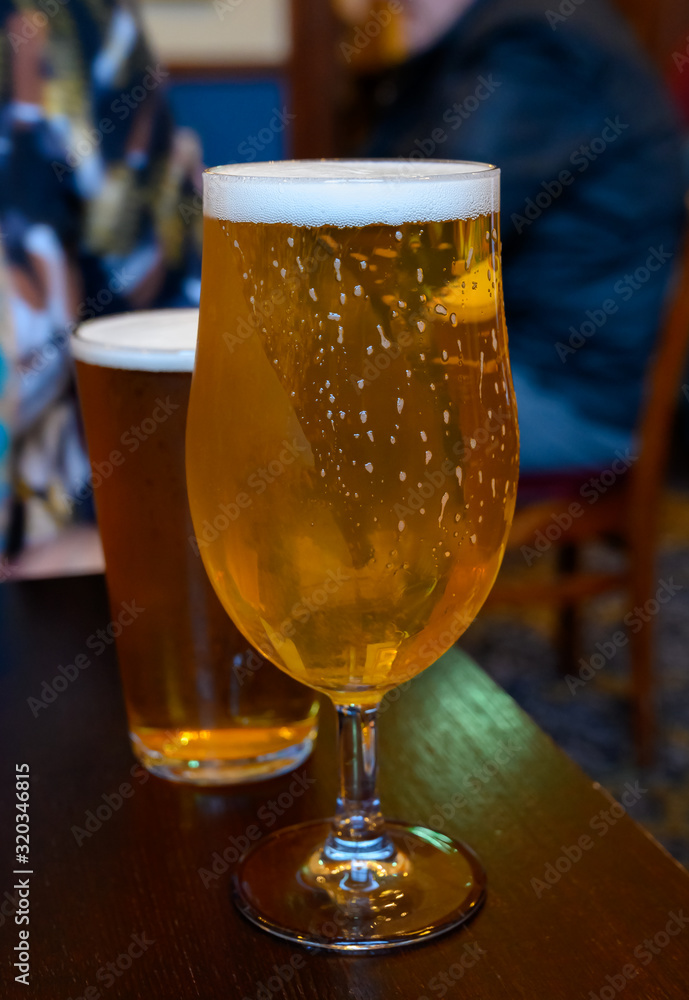 Misty glasses with two pints of cold Scotch ale, pale ale, lager draft beer in English pub Misty glasses with two pints of cold Scotch ale, pale ale, lager draft beer in English pub