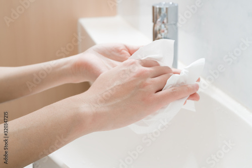 Asian woman hands being dried with tissue paper