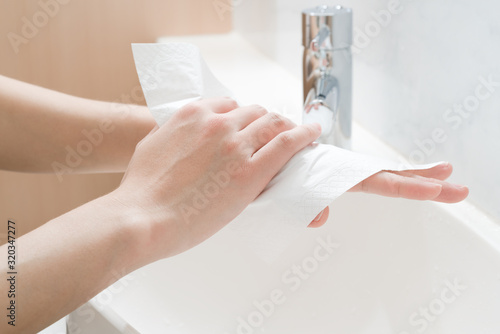 Asian woman hands being dried with tissue paper