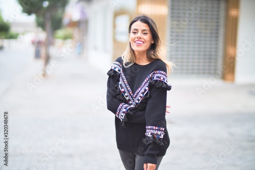 Young beautiful girl wearing sweater walking at street town