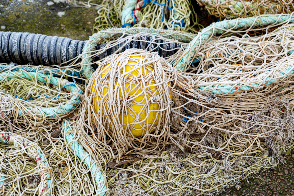 blue fishing net on a pontoon with its ropes and floats covered with morning frost blue fishing net on a pontoon with its ropes and floats covered with morning frost