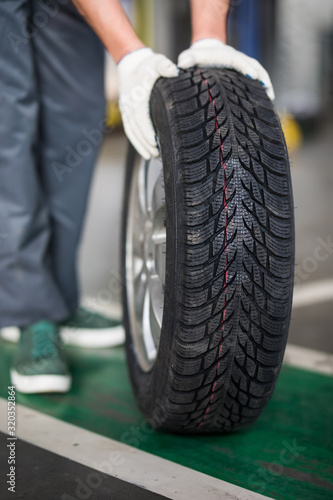 Auto mechanic carrying tire in tire store © F8  \ Suport Ukraine