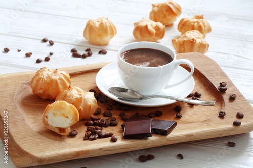 Profiteroles with coffee and chocolate on a white background photo