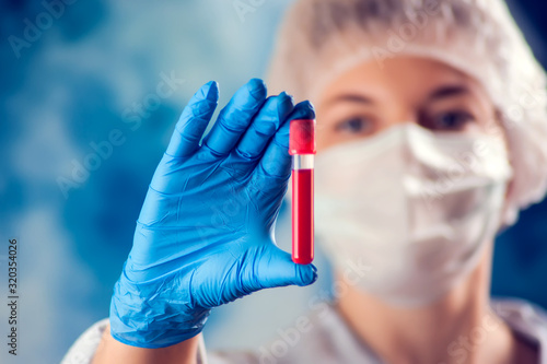 Doctor holding tube with blood test. Medicine and health care concept.