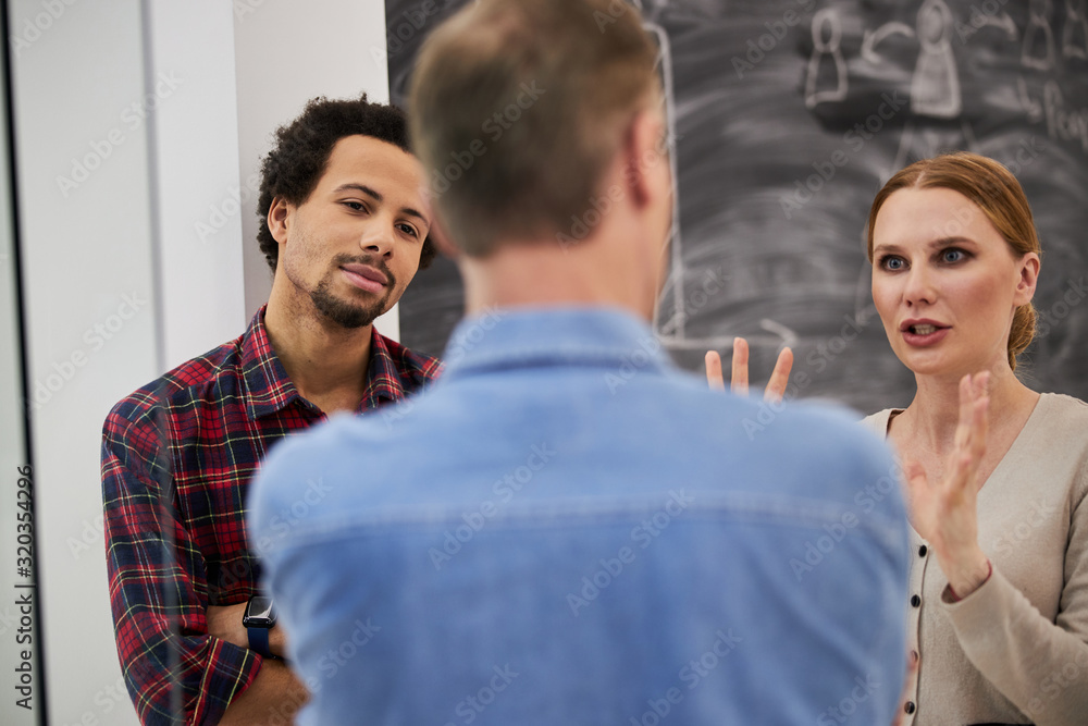 Obraz premium Pretty lady talking with colleagues at work