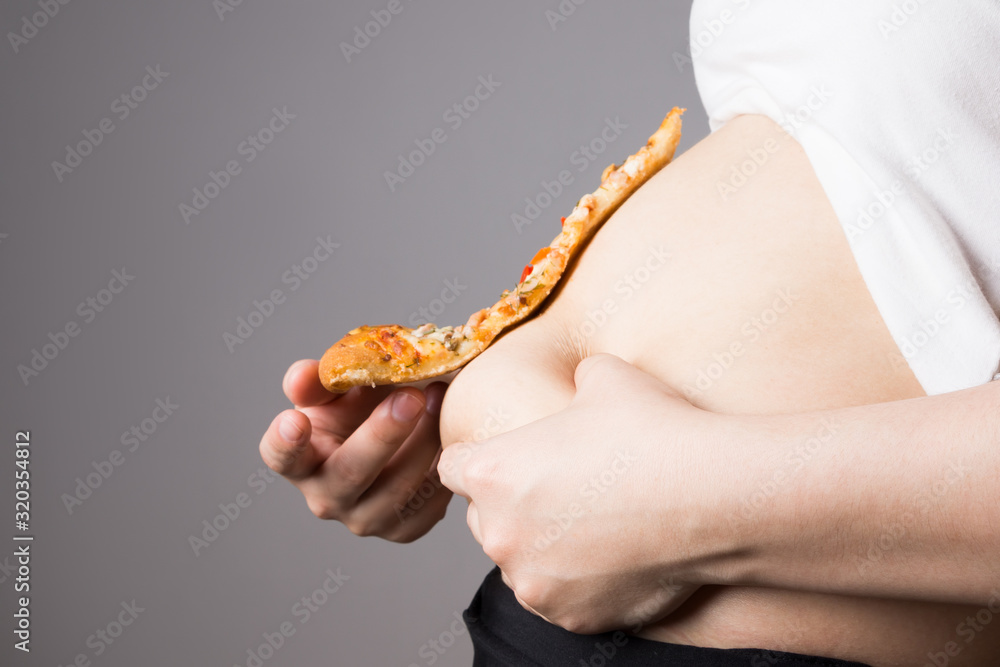 Fat woman with a piece of pizza, unhealthy nutrition concept Fat woman with a piece of pizza, unhealthy nutrition concept