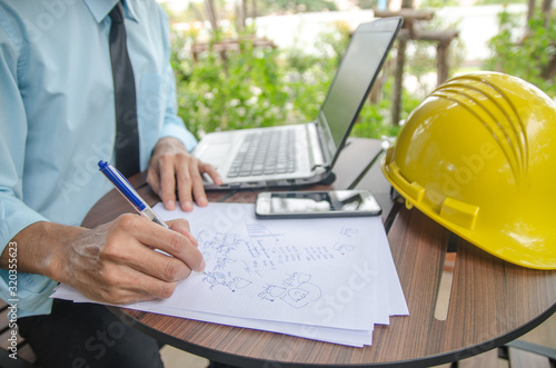 Close-up shot of a civil engineer writing a note in a notebook for architecture. photo