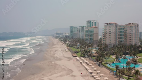 Aerial View of Acapulcp Beach on Low Tide, Ocean Waves, Condos, Hotels and Mist Over Horizon photo