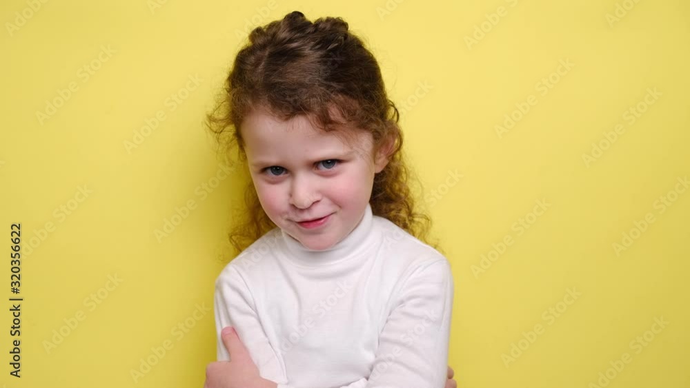 Portrait of upset offended abused little girl blows cheeks in dissatisfaction, expresses negative emotions and feelings, standing over yellow background. Unhappy child frowns face, shows antipathy Portrait of upset offended abused little girl blows cheeks in dissatisfaction, expresses negative emotions and feelings, standing over yellow background. Unhappy child frowns face, shows antipathy