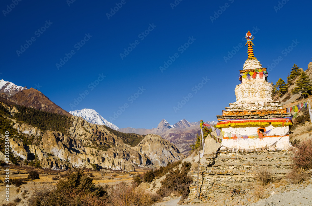 White stupa on the trekking route in Marshyangdi river valley between near Bhraka (Braga) village. Annapurna circuit trek, Nepal.