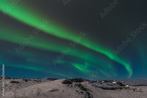 A beautiful northern lights also called Aurora Borealis over the Iceland. Winter time in Scandinavia is very magical and brings a lot of tourists from all over the world to see it