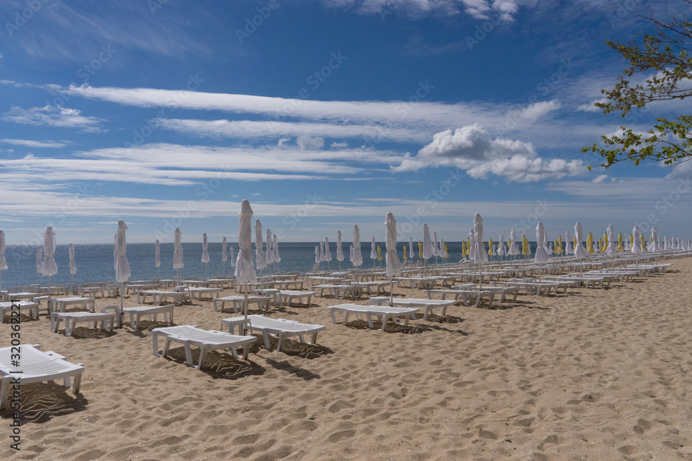 Leere Liegen am Strand in der Vorsaison Leere Liegen am Strand in der Vorsaison