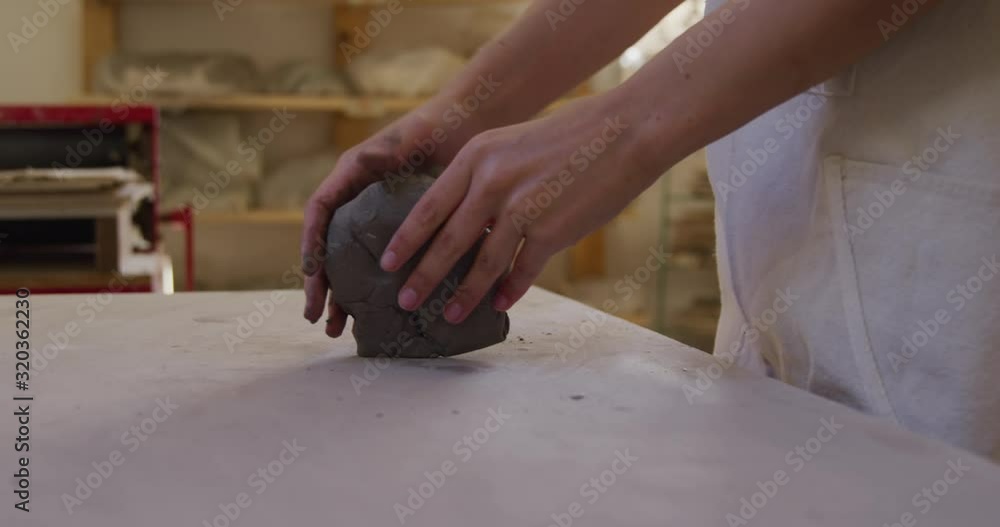 Young female potter working in her studio Young female potter working in her studio