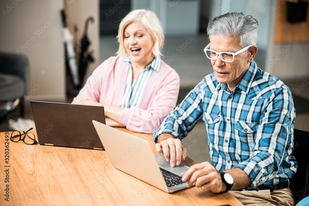 Adult smiling male talking to woman in the office Adult smiling male talking to woman in the office