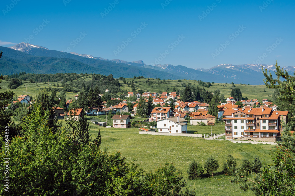 A picturesque summer landscape from Bulgaria, the Bulgarian mountain village of Madzhare against the background of Rila Mountain and clear blue sky.