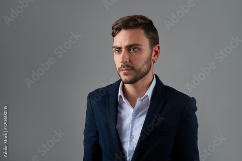 Close up portrait young man businessman. Caucasian guy business suit studio gray background.