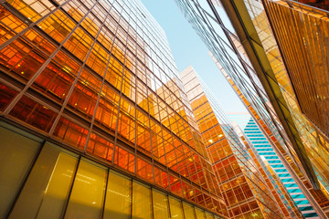 golden glass facade of modern  office building and blue sky
