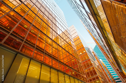 golden glass facade of modern office building and blue sky