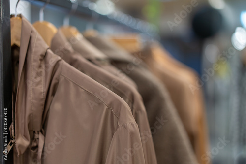 Pastel clothing shirts hang on hangers in a shop background. A variety of clothes  hanging in the wardrobe. © Andrii