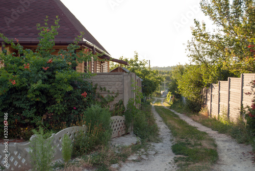 Village lane with beautiful landscape house and road