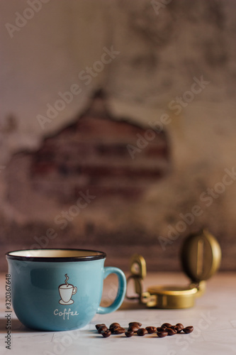 Black coffee in Blue cup on freshly roasted coffee beans background. Top view.