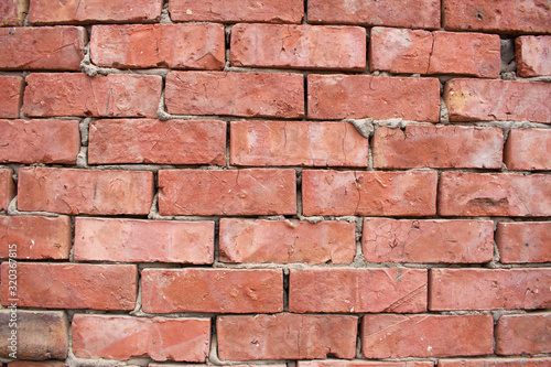 Brick wall made from light red bricks. Background of red brick wall close up.