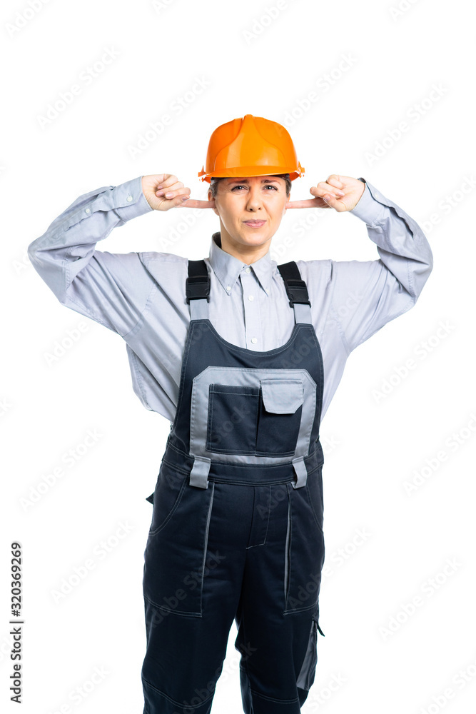 Female construction engineer does not want to hear anything. The construction site is working loudly. Isolated Female construction engineer does not want to hear anything. The construction site is working loudly. Isolated