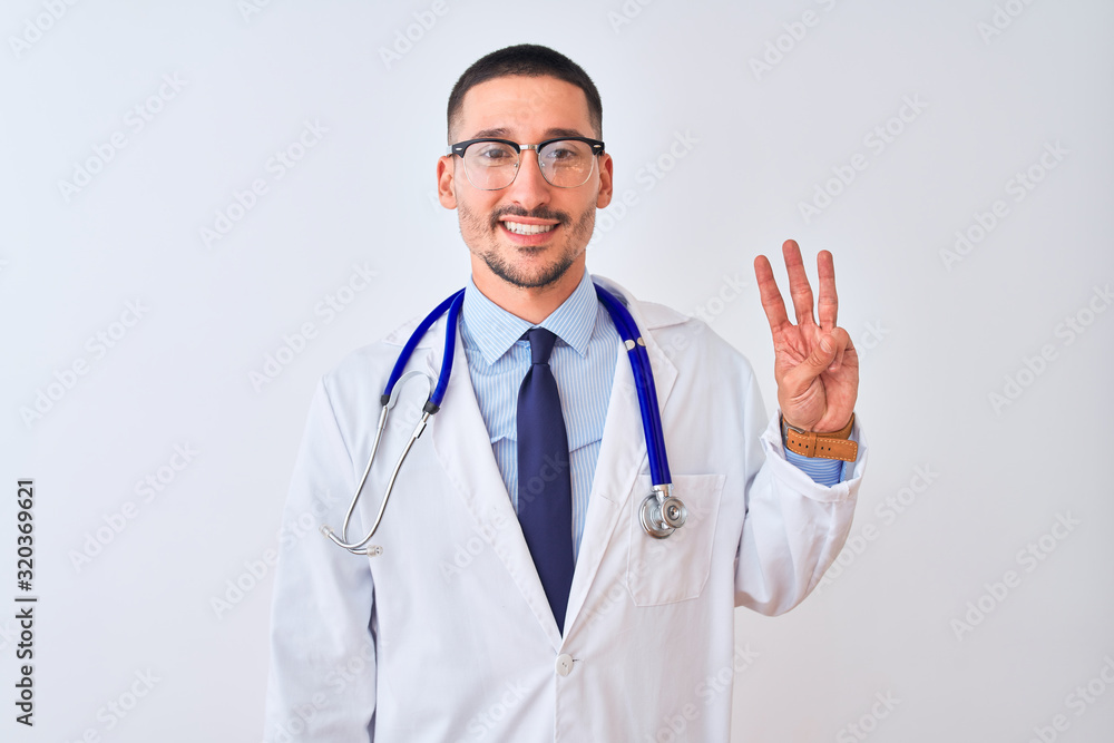 Young doctor man wearing stethoscope over isolated background showing and pointing up with fingers number three while smiling confident and happy.
