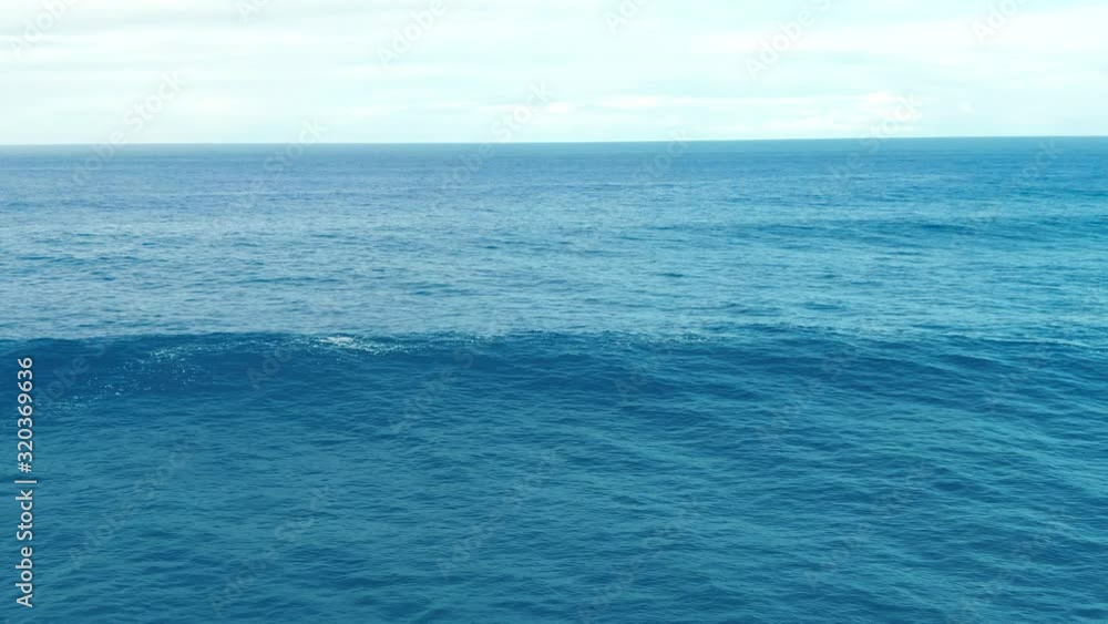 Close up of disturbed blue ocean water surface, big waves pass in calm Pacific ocean along the coast of Hawaii Close up of disturbed blue ocean water surface, big waves pass in calm Pacific ocean along the coast of Hawaii