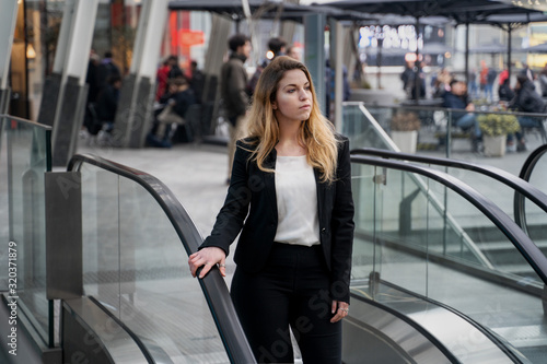 Blonde Businesswoman Using Escalator In Modern City © Gianandrea Villa