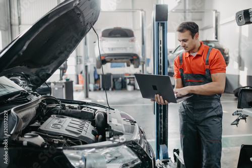 Professional man car mechanic working in auto repair service. photo